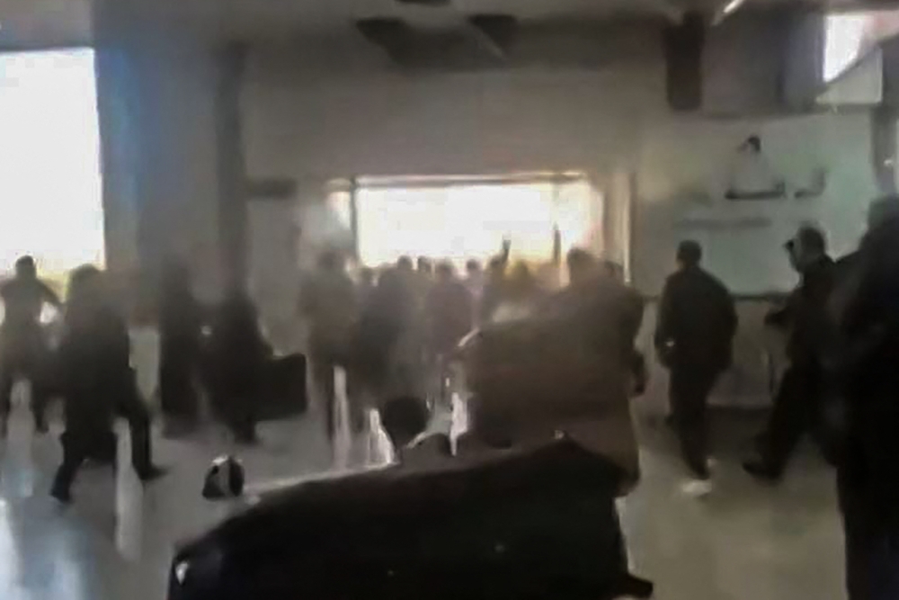 An image grab from UGC footage posted on social media on reportedly shows travelers rushing in panic out of Sanaa international airport after it was hit by an Israeli strike. — AFP
