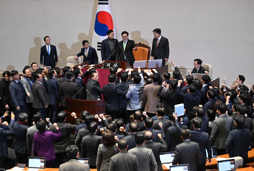 South Korea’s ruling People Power Party lawmakers (bottom) argue to National Assembly Speaker Woo Won-shik (2nd right top) during the plenary session for the impeachment vote of acting president Han Duck-soo at the National Assembly in Seoul December 27, 2024. — AFP pic