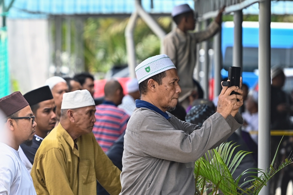 Members of the public attempting to catch a glimpse of the public caning punishment against a 42-year-old man convicted of repeated “khalwat”, or close proximity with the opposite sex in Kuala Terengganu. — Bernama pic