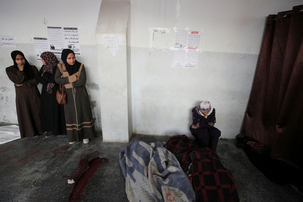 Mourners react next to the bodies during the funeral of Palestinians killed in Israeli airstrikes, amid the Israel-Hamas conflict, in Gaza City, December 27, 2024. — Reuters pic