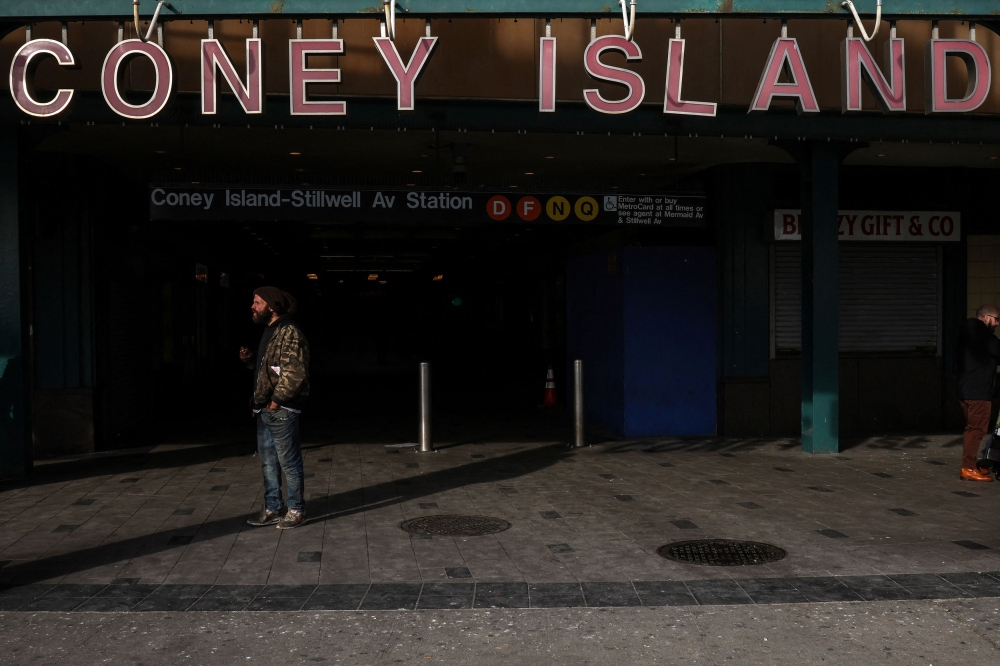 A man stands in front of a subway entrance at Coney Island in New York December 27, 2024. According to the police account, Zapeta used a lighter to ignite the clothes of a woman who appeared to be sleeping on a stationary F train at the Coney Island-Stillwell Avenue subway station on Sunday. — Reuters pic