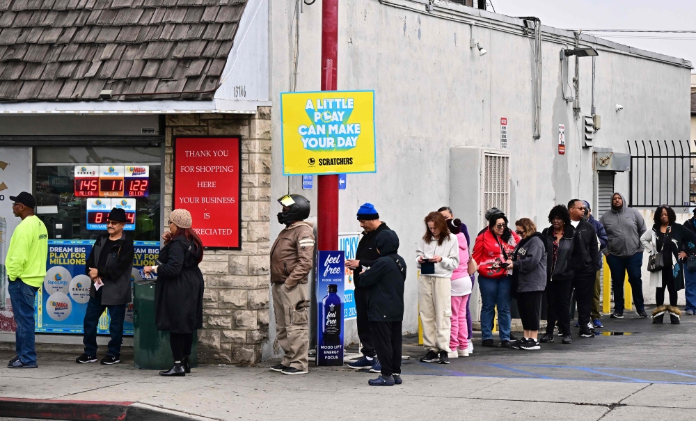 People wait in line to purchase their Mega Millions lottery ticket from a liquor store where winning tickets have been sold on December 27, 2024 in Hawthorne, California. — AFP pic 