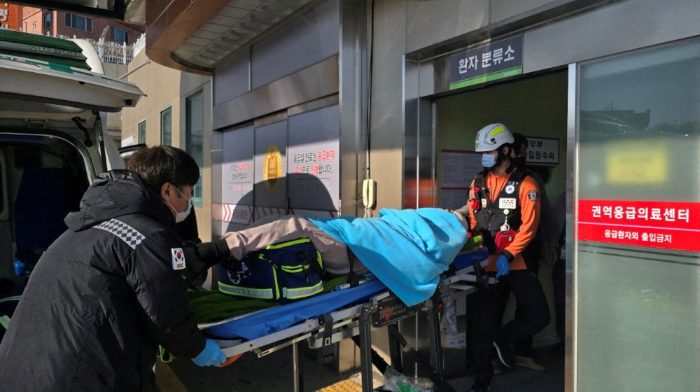 A passenger who was rescued from an aircraft which drove off runway at Muan International Airport is carried to a hospital in Mokpo, South Jeolla Province, South Korea, December 29, 2024. — Yonhap handout pic via Reuters 