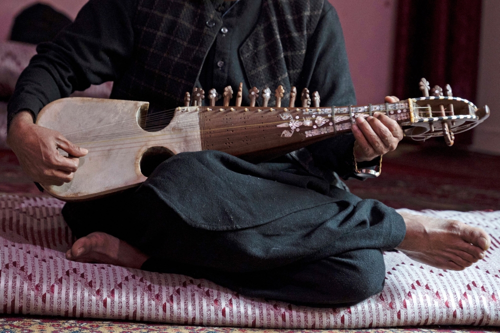 Afghan musician Majid plays the rubab instrument at a house in Kabul December 17, 2024. — AFP pic