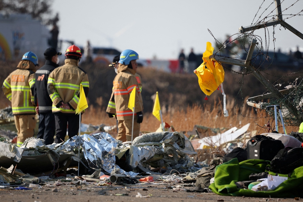 A life jacket hangs on fencing next to the wreckage of an aircraft that crashed after it went off the runway at Muan International Airport, in Muan, South Korea, December 29, 2024. — Reuters pic 