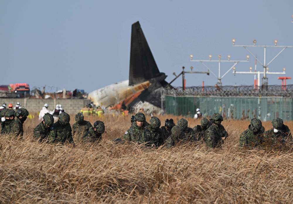 South Korean soldiers search for missing passengers near the wreckage of a Jeju Air Boeing 737-800 series aircraft after the plane crashed and burst into flames at Muan International Airport in South Jeolla Province on December 29, 2024. — AFP pic