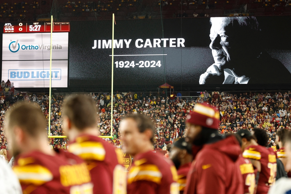 A moment of silence for the passing of former President Jimmy Carter is observed prior to the game between the Washington Commanders and Atlanta Falcons at Northwest Stadium. — Geoff Burke-Imagn Images pic via Reuters 