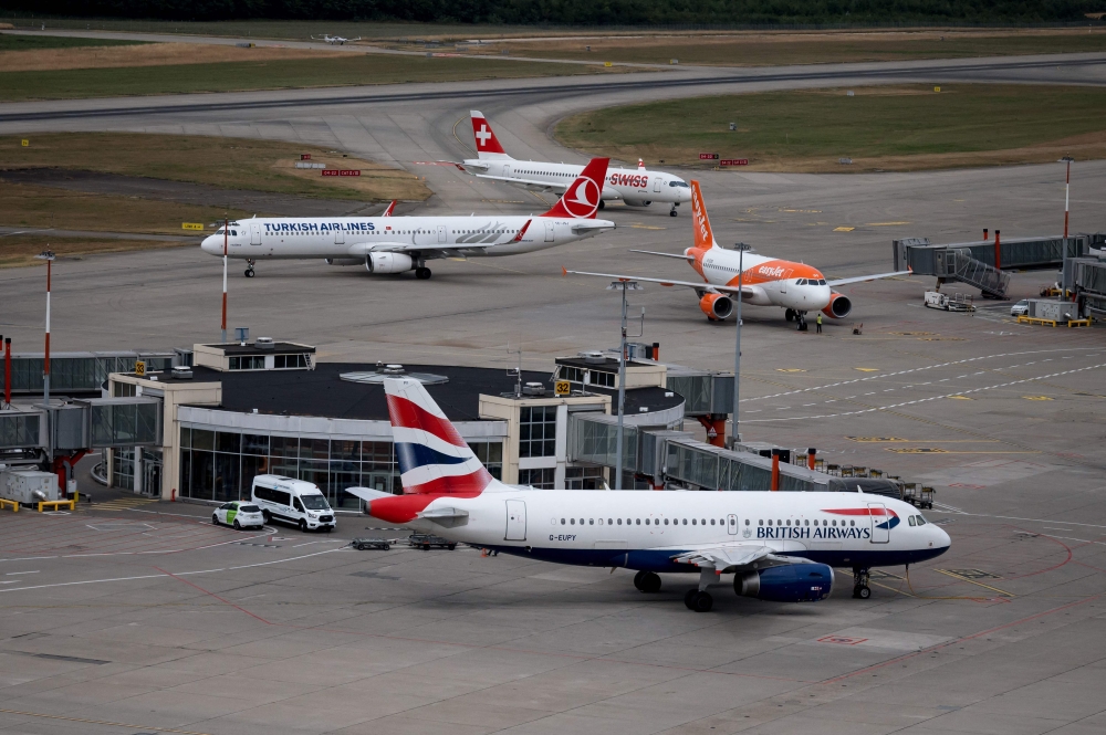 File photograph taken in Geneva on July 28, 2022 shows planes of carriers British Airways, Swiss International Air Lines, EasyJet and Turkish Airlines seen from the Geneva Airport air traffic control. A Swiss International Air Lines cabin crew member on an aeroplane forced to make an emergency landing due to smoke inside the aircraft has died, the flag carrier said yesterday. — AFP pic