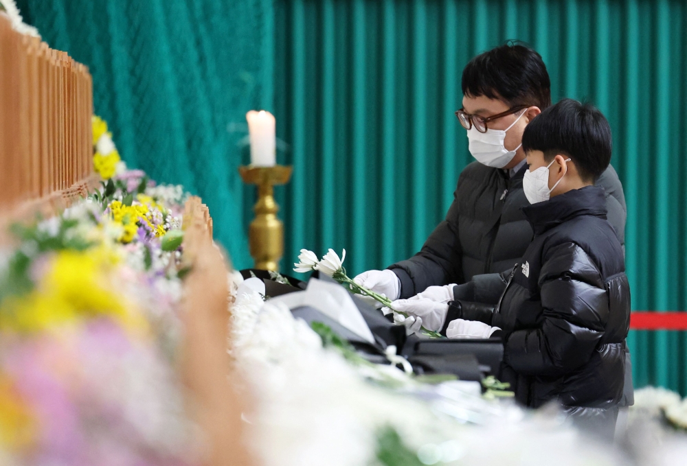 Mourners pay their respects at a memorial altar for victims of the Jeju Air plane crash, at Muan Sports Park. — AFP