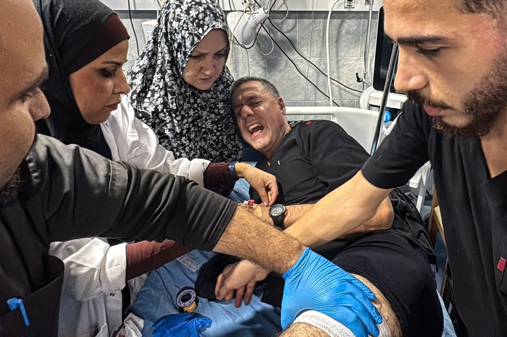 Hossam Abu Safiyeh, director of the Kamal Adwan Hospital, is treated by colleagues for his injuries following an Israeli strike that according to the civil defence in Gaza hit the medical compound in Beit Lahia in the northern Gaza Strip, late on November 23, 2024. — AFP pic