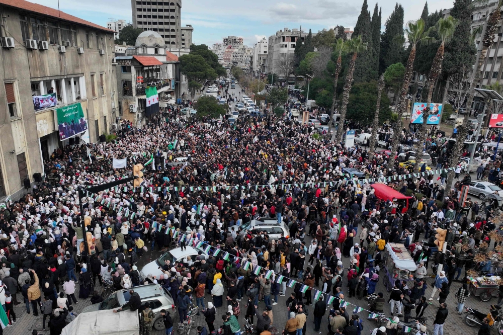 This aerial view shows people celebrating the ouster of Syria's president Bashar al-Assad, in the centre of Homs on December 30, 2024. — AFP pic