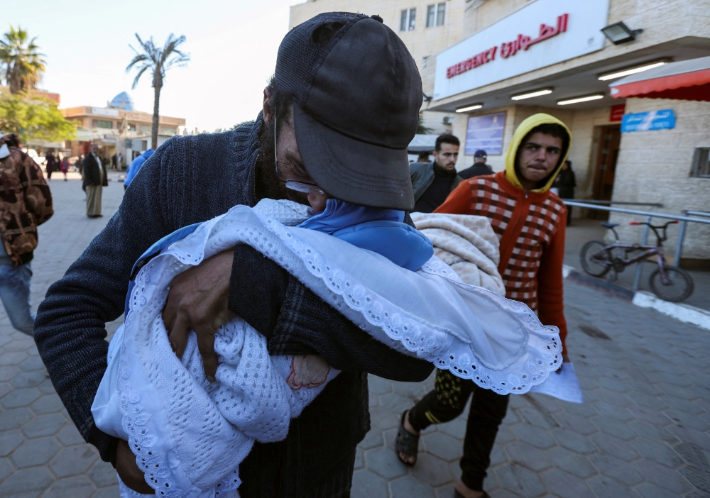 Yahya Al-Batran, the father of Palestinian infant Jumaa Al-Batran, who died of hypothermia after living in a tent with his displaced family, reacts as he embraces his body at Al-Aqsa Martyrs Hospital, in Deir Al-Balah in the central Gaza Strip, December 29, 2024. — AFP pic