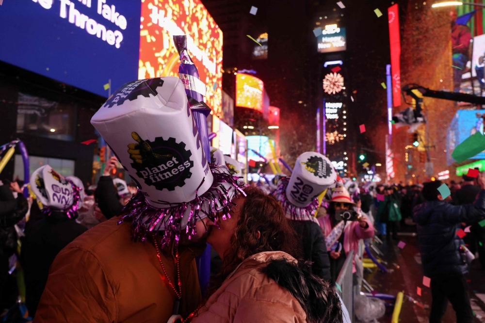 Revelers kiss as they celebrate the New Year at Times Square in New York City, just after midnight on January 1, 2025. — AFP pic
