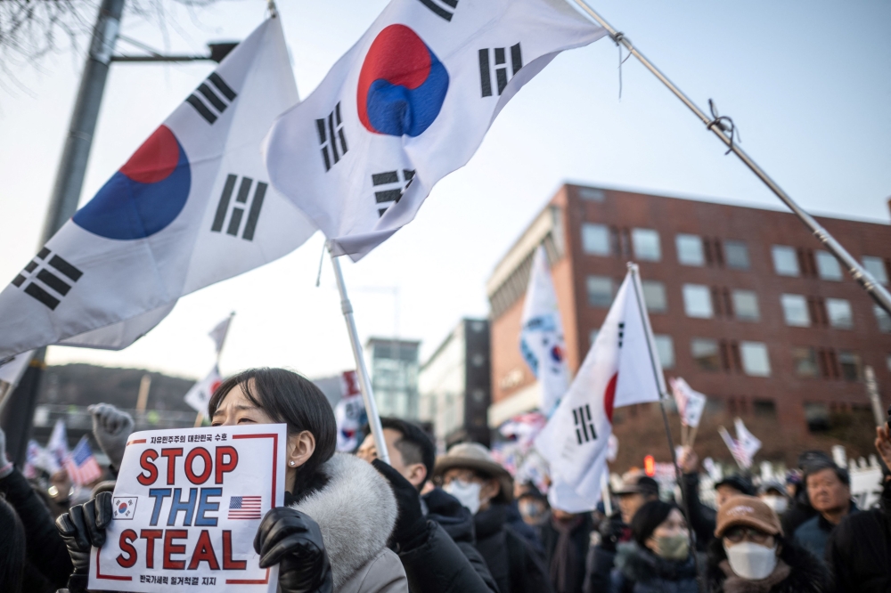 A participant holds a placard reading ‘Stop the Steal’ during a rally to support impeached South Korea’s President Yoon Suk Yeol near the presidential residence in Seoul. — AFP