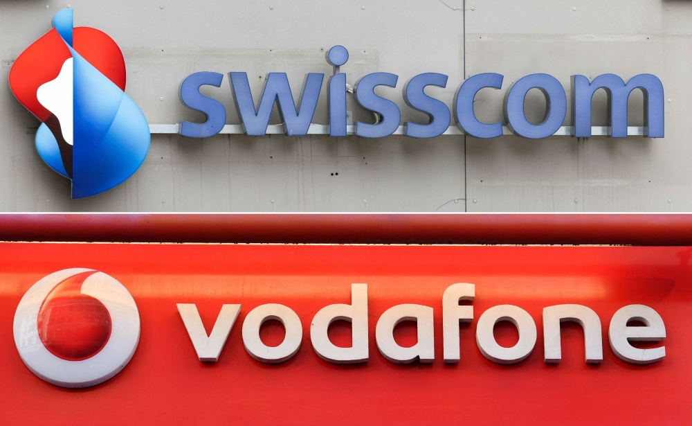 A composite photograph shows the logos of Swiss telecommunication company Swisscom (top) and the logo of British mobile phone giant Vodafone. The latter finalised its sale of Vodafone Italy to Swisscom for €8 billion on January 2, 2025.  — AFP pic