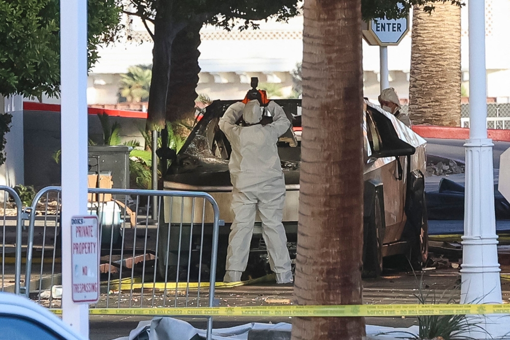An investigator photographs a Tesla Cybertruck that exploded outside the lobby of President-elect Donald Trump's hotel January 1, 2025, in Las Vegas. At least one person was killed and seven wounded when a Tesla Cybertruck exploded outside a hotel belonging to US President-elect Donald Trump in Las Vegas, police said Wednesday. — AFP pic