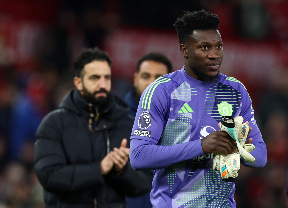 Manchester United's Portuguese head coach Ruben Amorim (left) and Manchester United's Cameroonian goalkeeper #24 Andre Onana leave the pitch after the English Premier League football match between Manchester United and Newcastle United at Old Trafford in Manchester, north west England, on December 30, 2024. — AFP pic