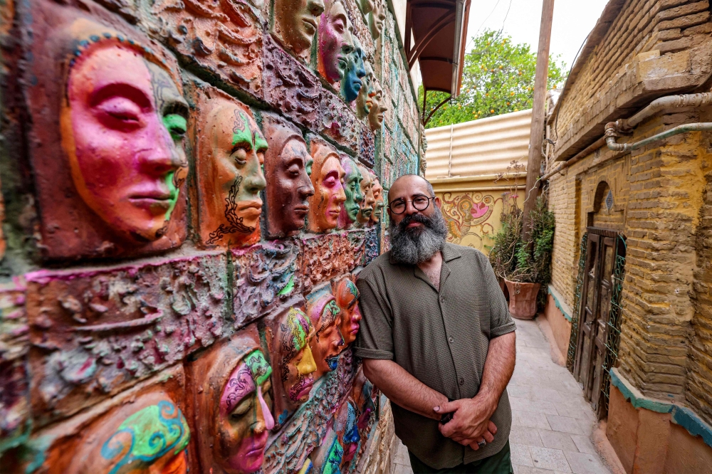 Adel Yazdi, an Iranian artist who has transformed an alley in one of the old neighbourhoods of Shiraz into an open air permanent art gallery, stands next to one of his high reliefs in the central Iranian city on May 14, 2024. — AFP pic 