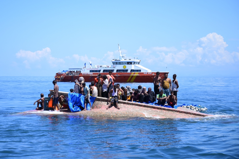 Rohingya refugees waiting to be rescued as their vessel approaches Aceh last year. — AFP pic