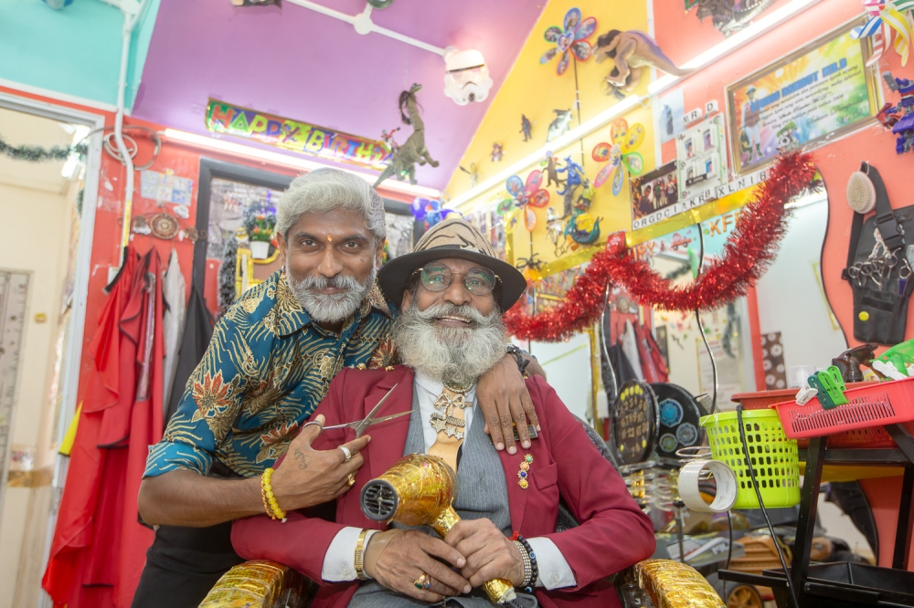 Darmalingam Manickam (right) and his son Sivarajah Darmalingam posing for a picture at their Mr D Hair Studio salon in Bandar Baru Bangi recently. — Picture by Raymond Manuel