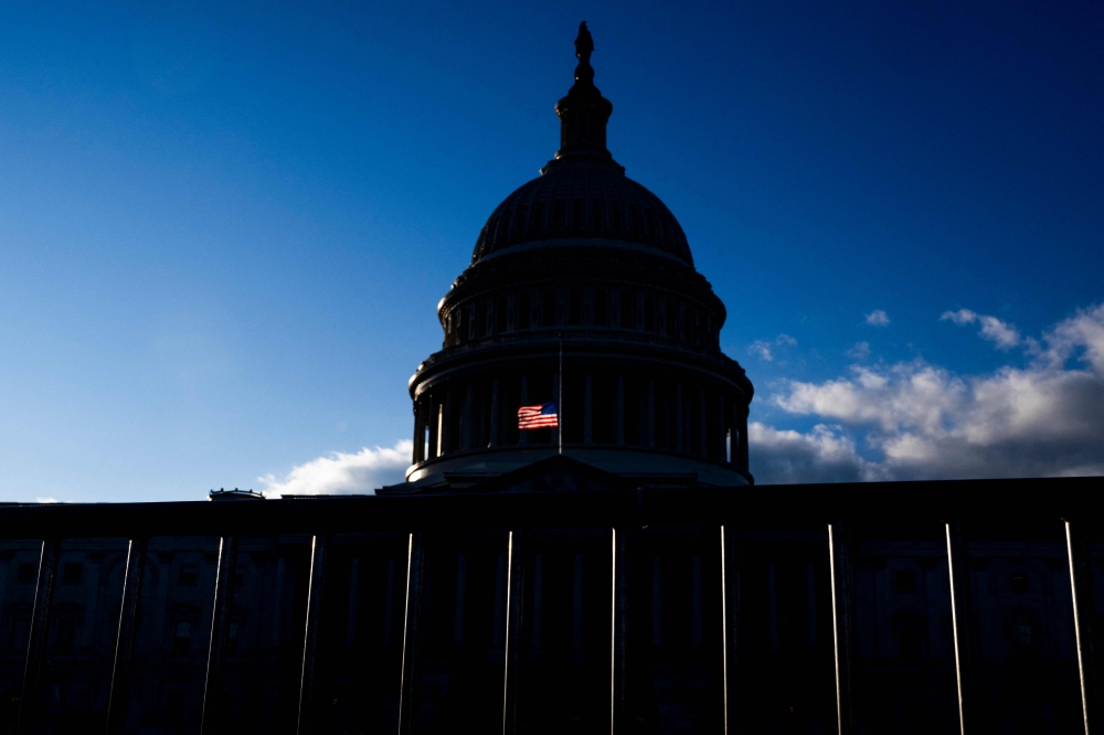 A US flag, flying half-staff in remembrance of late former US President Jimmy Carter, flutters near the dome of the US Capitol building in Washington. — AFP