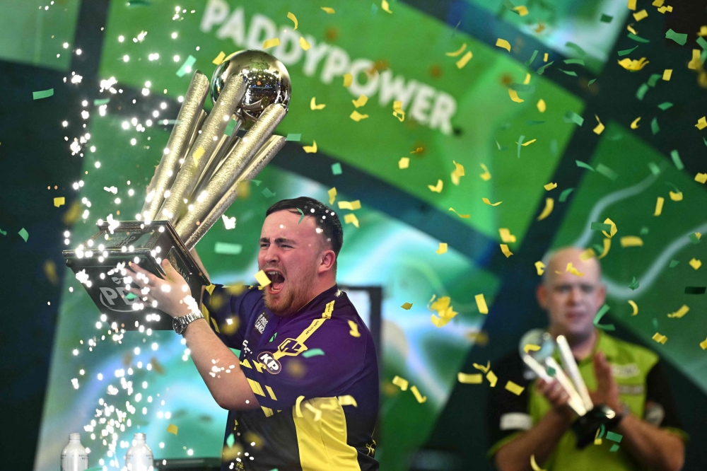 England's Luke Littler celebrates with the Sid Waddell Trophy after victory over Netherlands' Michael van Gerwen in the PDC World Darts Championship final, at Alexandra Palace in London on January 3, 2025. — AFP pic