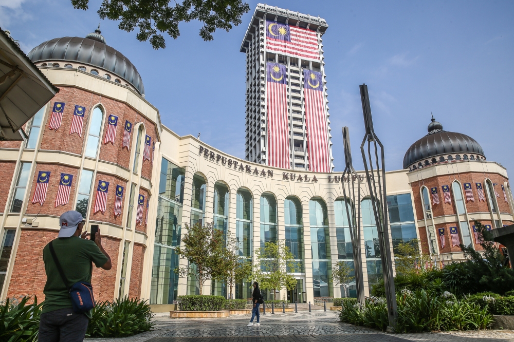 Tourists take pictures with the Kuala Lumpur Library as their backdrop on August 24, 2023. — Picture by Yusof Mat Isa