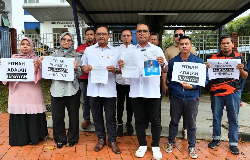 Selangor Pakatan Harapan Vice Chairman Azli Yusof (3rd left) with Head of Information Abbas Salimi Che Adzmi @ Azmi (3rd right) pose for a picture after filing a police report against Sungai Burong State Assemblyman Mohd Zamri Mohd Zainuldin for malicious accusations against the Prime Minister at Police Station Section 9 Shah Alam January 4, 2025. — Bernama pic