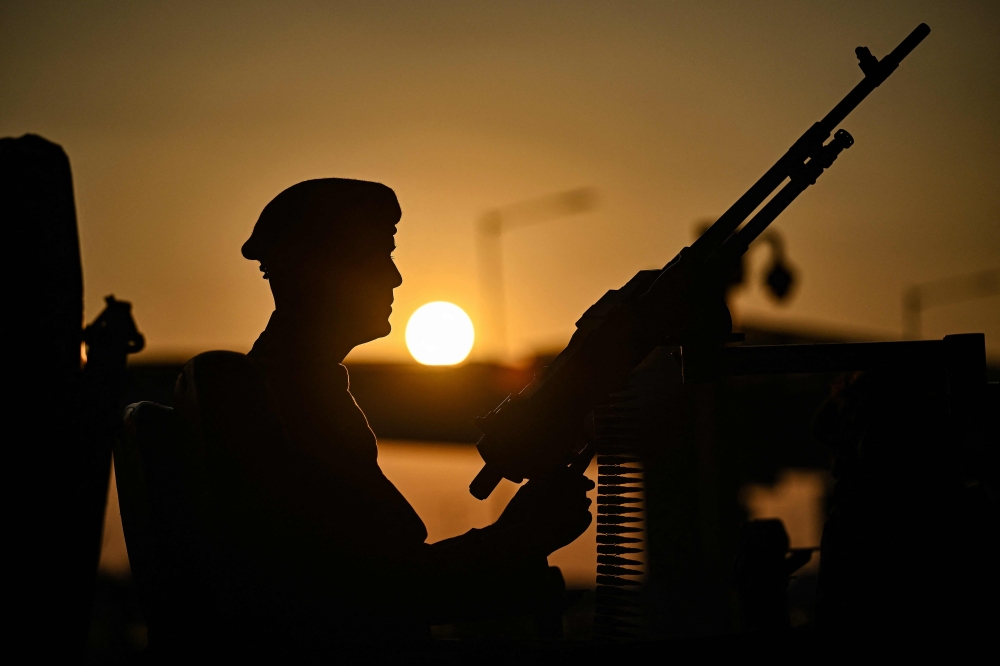 An Indian army soldier holding a rifle is silhouetted against the setting sun, during a weapons’ and equipment exhibition held ahead the upcoming 77th Indian Army Day, at the Kempegowda International Airport in Bengaluru on January 4, 2025. Indian security forces today battled with Maoist rebels in their forested heartland, police said, with at least four guerillas and one policeman killed. — AFP pic