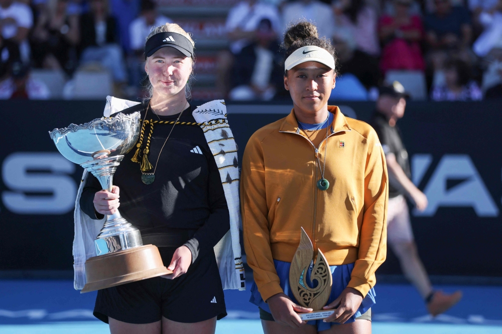 Clara Tauson of Denmark (left) celebrates with the trophy after her win over Naomi Osaka of Japan (right), following Osaka's retirement from their women's singles final match due to an abdominal injury, at the WTA Auckland Classic tennis tournament in Auckland January 5, 2025. — AFP pic