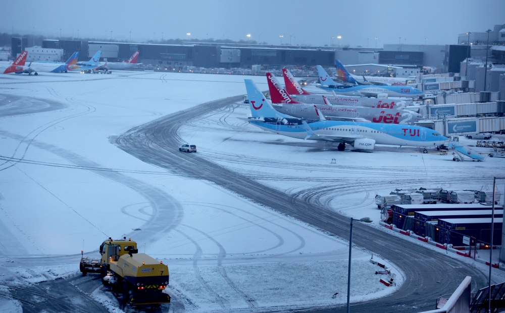 A snow plough waits to help clear snow from around aircraft after overnight snowfall caused the temporary closure of Manchester Airport in Manchester January 5, 2025. — Reuters pic  