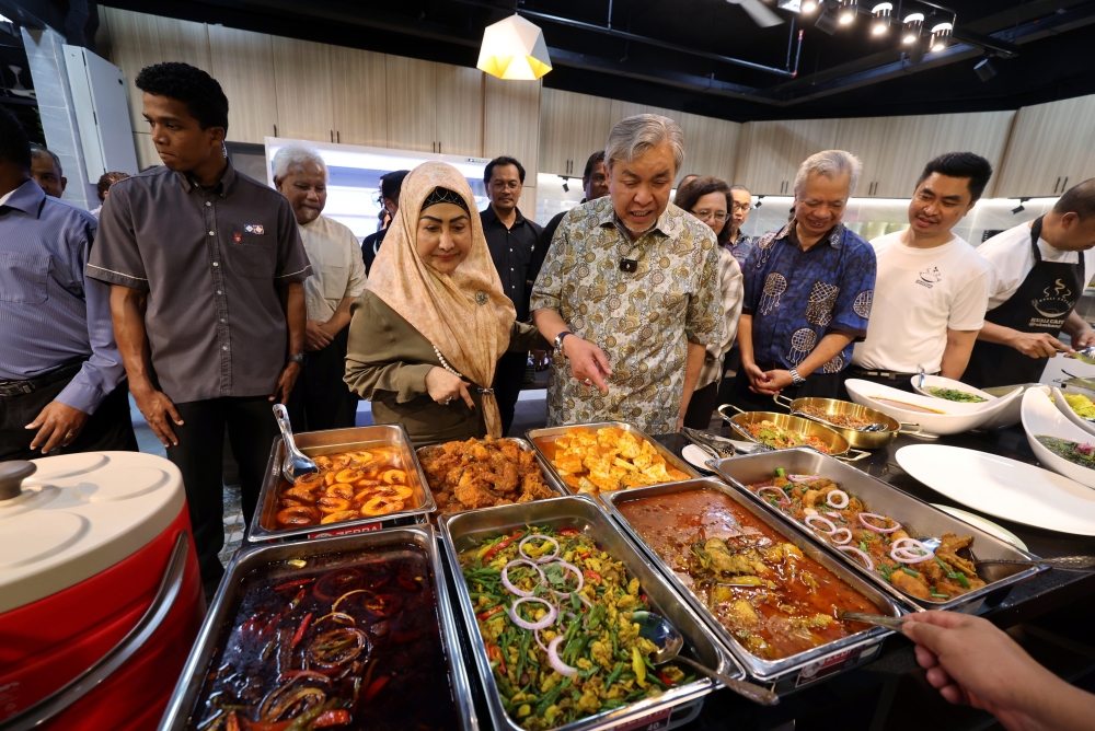 Deputy Prime Minister and Minister of Rural and Regional Development Datuk Seri Dr Ahmad Zahid Hamidi (third from right), accompanied by his wife, Datin Seri Hamidah Khamis, observing the dishes at the opening ceremony of Kuali Cafe@UKM at the Pusanika Building, Universiti Kebangsaan Malaysia (UKM), here today. — Bernama pic