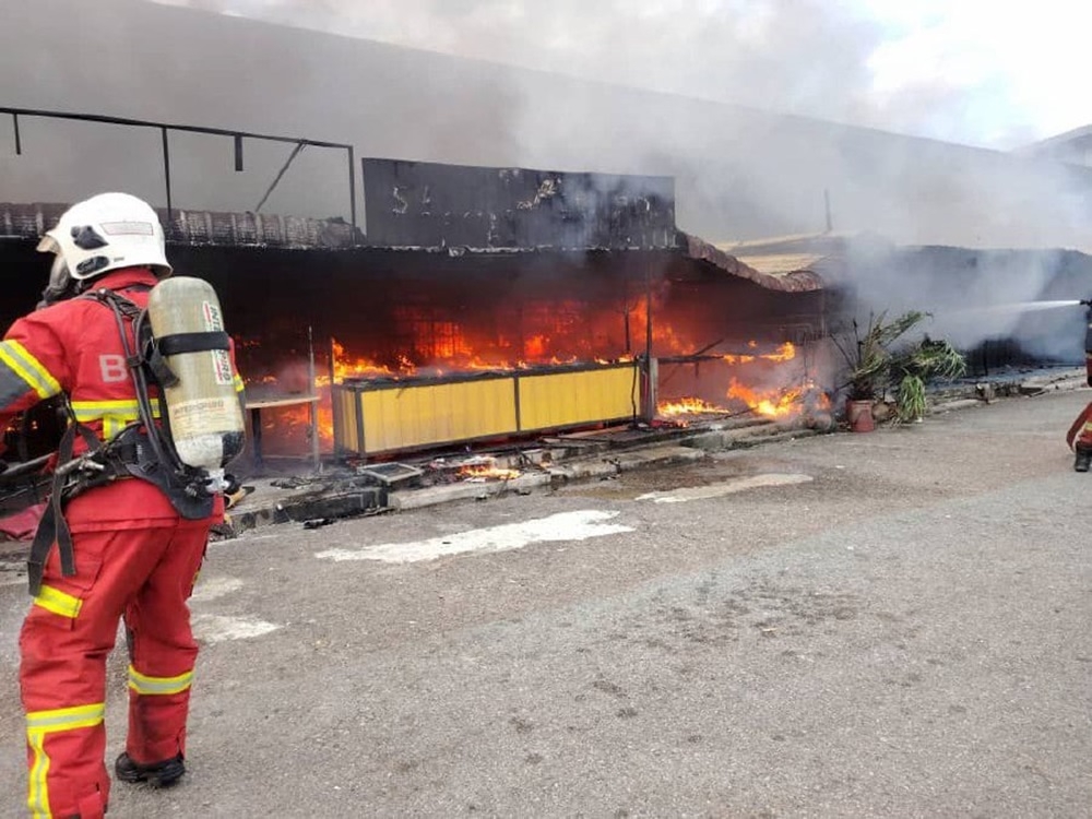 A trader suffered burns to his left hand during a fire that razed eight food stalls in Taman Sri Puteri, Skudai here yesterday afternoon. — Picture courtesy of the Fire and Rescue Department 