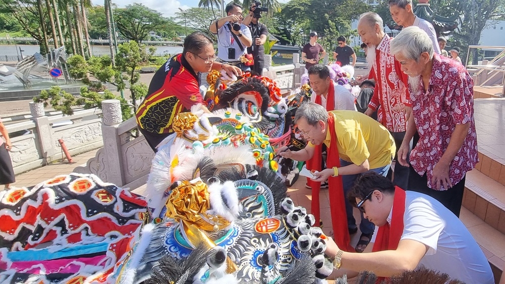 Deputy Premier Datuk Amar Dr Sim Kui Hian (centre) performs the eye-dotting ritual at the Tua Pek Kong temple in preparation for the upcoming Chinese New Year festival. — The Borneo Post pic 