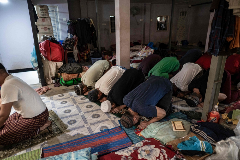 This photo taken on December 14, 2024 shows recovering drug addicts pray before lunch during a rehabilitation program at the Metta Saneain drug addict rehab centre in Yangon. — AFP pic