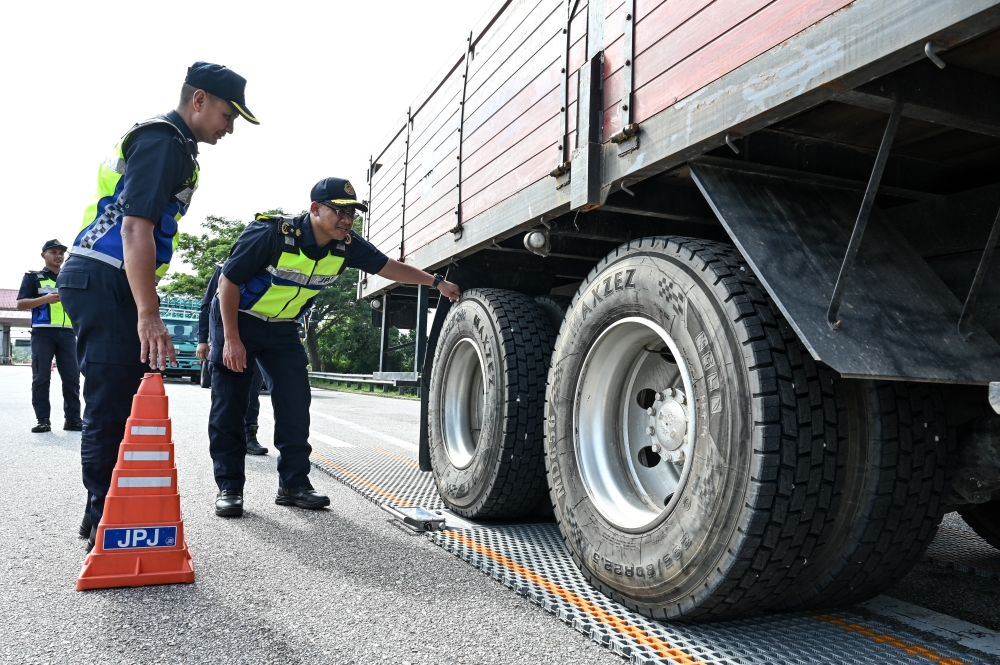 Terengganu Road Transport Department Director Mohd Zamri Samion (second left) inspects the condition of a lorry’s tyre during the Ops Gempur Teknikal at the Gemuruh Toll Plaza, Kuala Terengganu. — Bernama pic