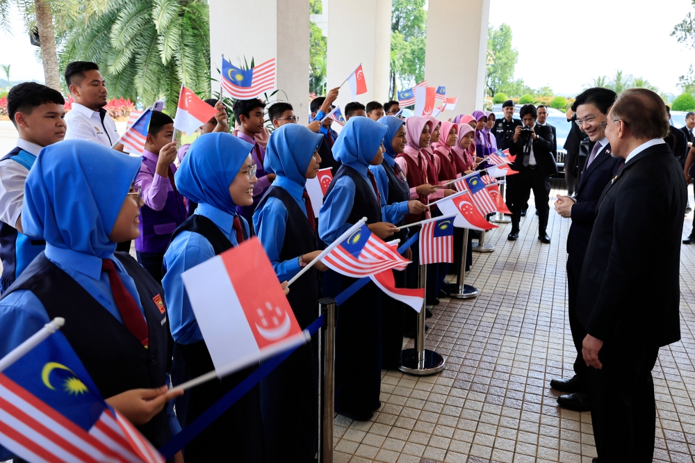 Prime Minister Datuk Seri Anwar Ibrahim and his Singapore counterpart interact with pupils from Sekolah Kebangsaan Presint 8(1) in Putrajaya January 7, 2025. — Bernama pic