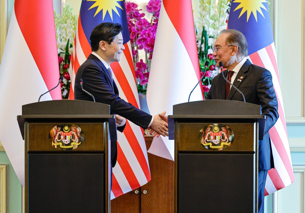 Prime Minister Datuk Seri Anwar Ibrahim and his Singaporean counterpart Lawrence Wong (left) shake hands during a joint news conference in Putrajaya January 7, 2025. — Bernama pic