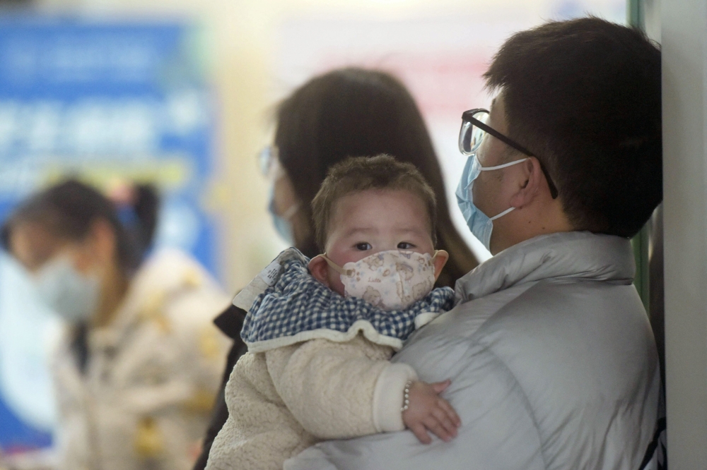 A baby wearing a face mask waits with family members at the pediatric department of a hospital in Hangzhou, eastern China’s Zhejiang province, on January 6, 2025. Beijing has acknowledged a surge in cases of the flu-like human metapneumovirus (HMPV), especially among children, and attributed this to a seasonal spike. — AFP pic 
