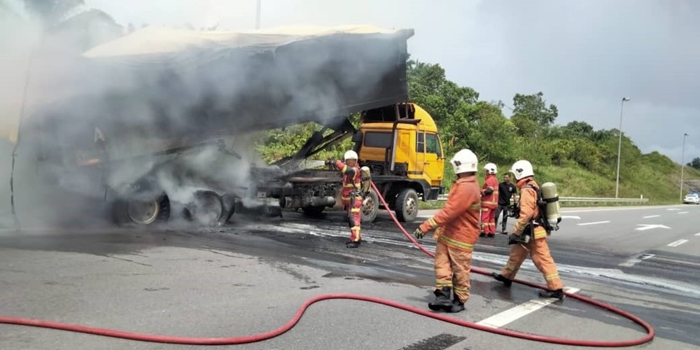 Handout photo shows firefighters putting out the fire that destroys the lorry. — Picture courtesy of the Fire and Rescue Department 