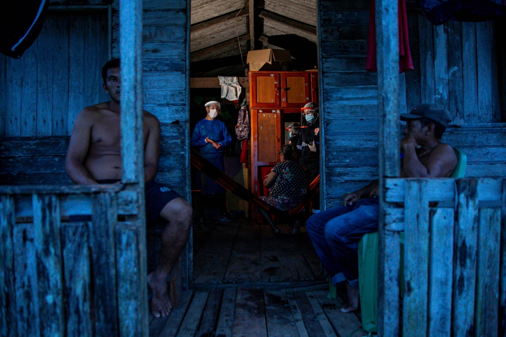 Government health workers test a resident of the Roli Madeira riverside community amid concern over the spread of the COVID-19 coronavirus, in the southwest of Marajo Island, in the state of Para, Brazil, on June 1, 2020. — AFP pic