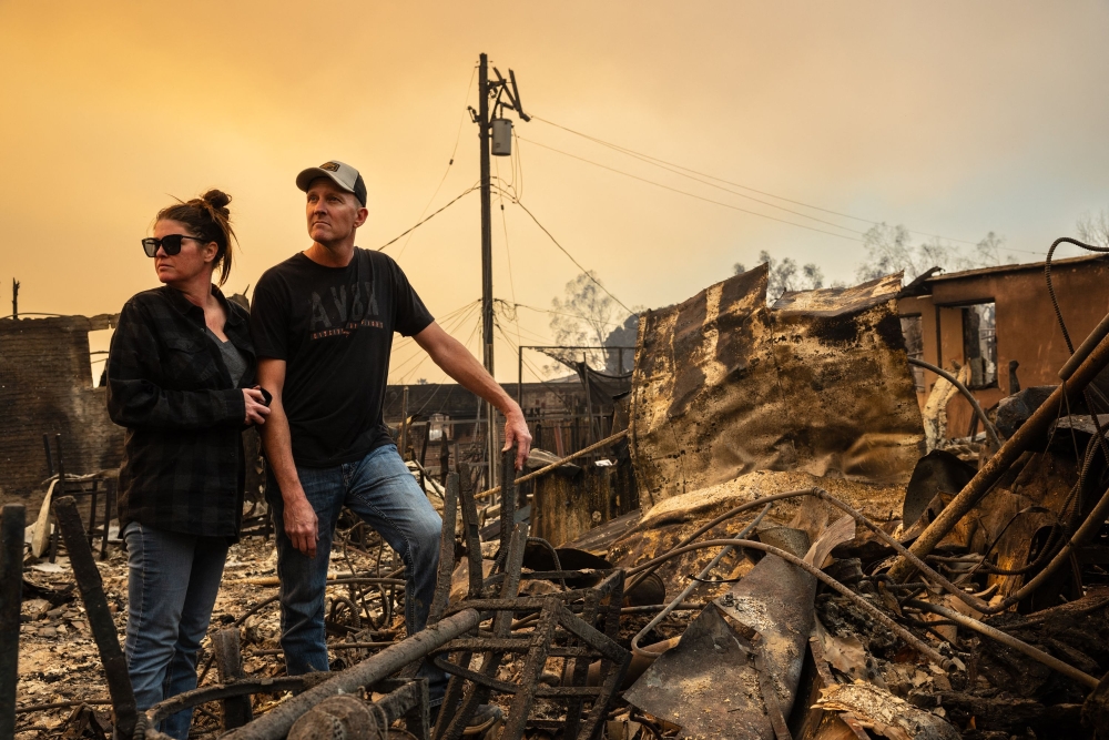 Chris and Christina Larson survey the ruins of their business, the Rancho Bar, which was  destroyed by the Eaton Fire in Altadena, California. — AFP