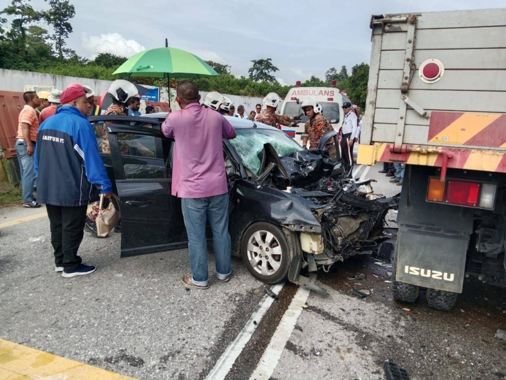 Emergency personnel at the scene of the Gua Musang crash, where one was killed and three family members were critically injured. — Picture via Facebook