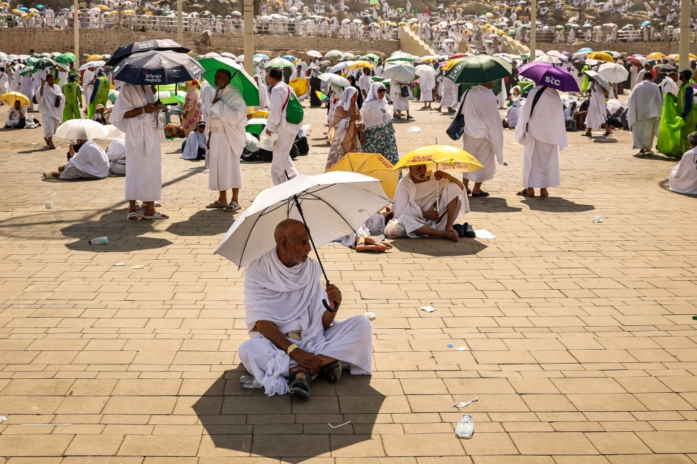 Muslim pilgrims use umbrellas to shade themselves from the sun as they arrive at the base of Mount Arafat, also known as Jabal al-Rahma or Mount of Mercy, during the annual hajj pilgrimage on June 15, 2024. — AFP pic