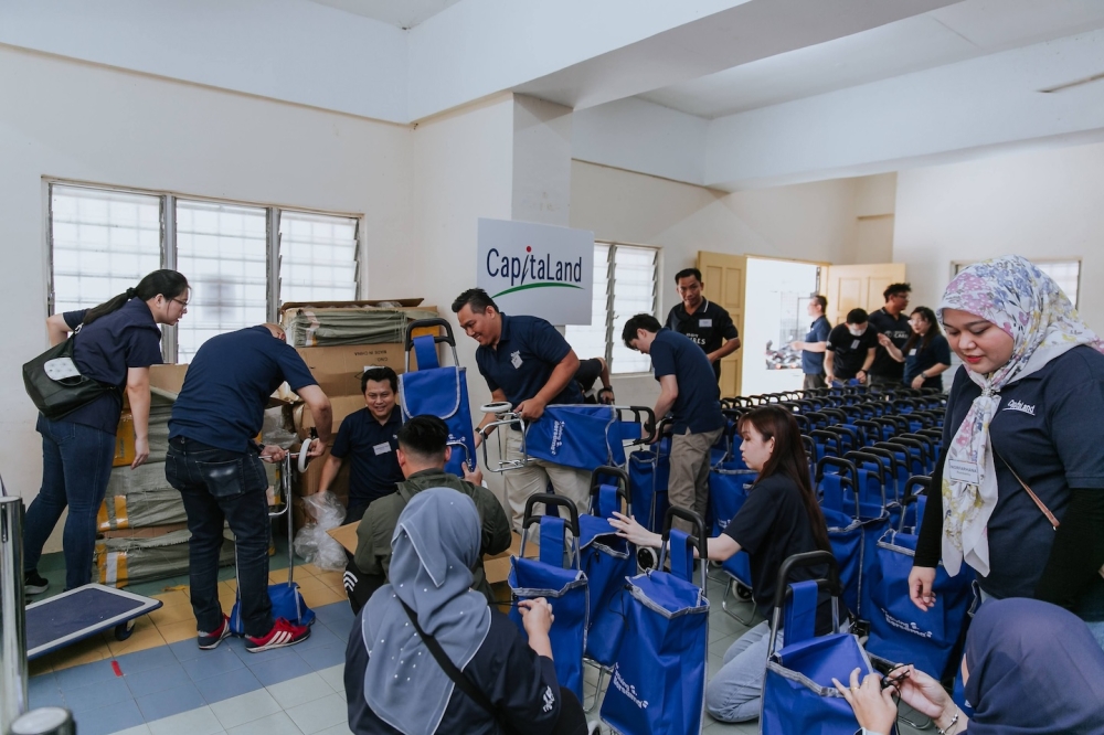Staff volunteers from CapitaLand assembling and preparing reusable trolley shopping bags for the beneficiaries before the bazaar.  — Picture courtesy of CapitaLand