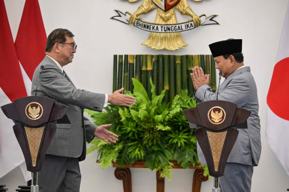 Japan's Prime Minister Shigeru Ishiba (left) extends a handshake toIndonesia's President Prabowo Subianto at the presidential palace in Bogor, West Java, on January 11, 2025. — AFP pic