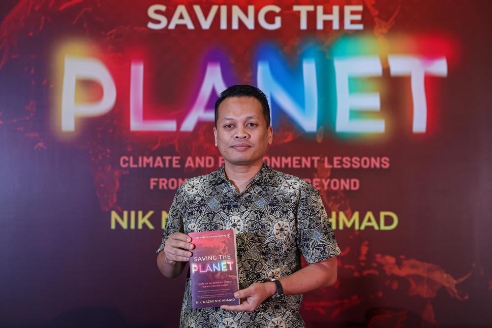 Natural Resources and Environmental Sustainability Minister, Nik Nazmi Nik Ahmad, holds a copy of his book ‘Saving The Planet’ which he launched at Sentul Depot in Kuala Lumpur January 11, 2025. — Bernama pic
