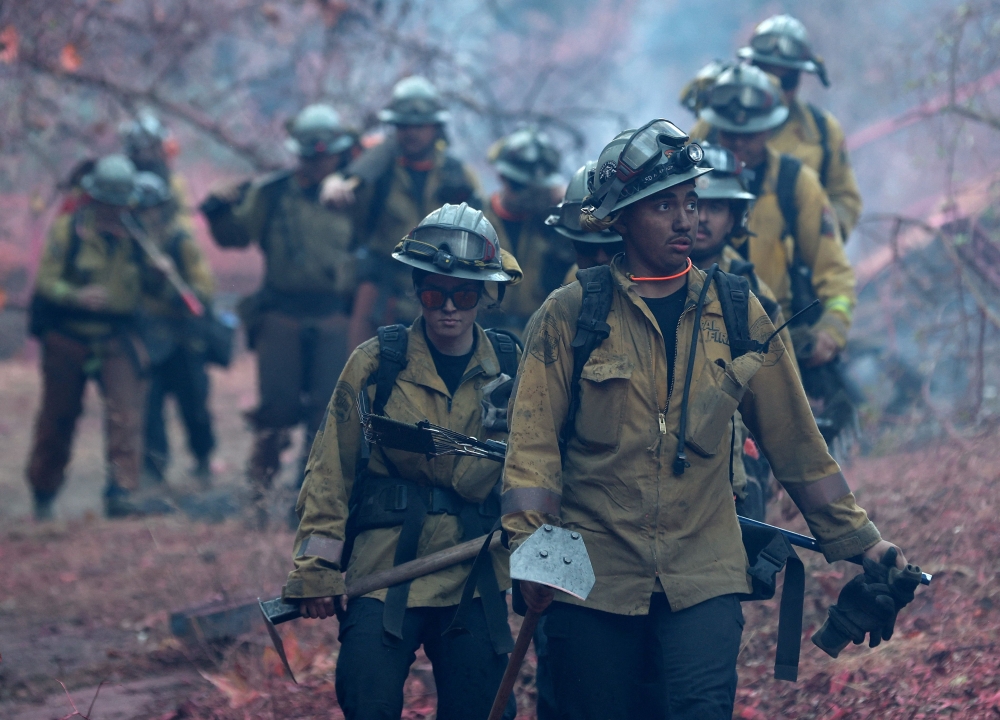 Firefighters walk down a hill as they battle the Palisades Fire on January 10 in Los Angeles, California. —  AFP pic