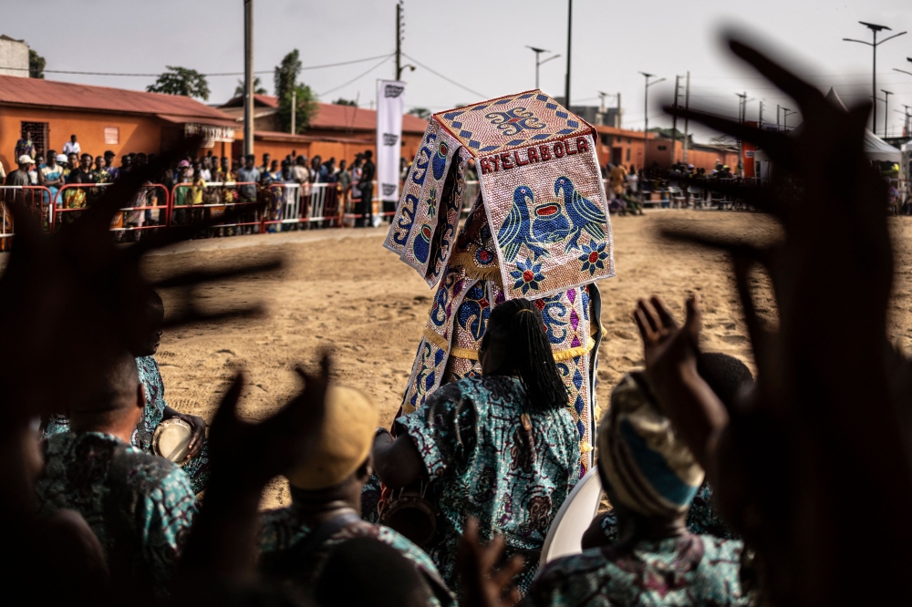 An Egungun, a visible manifestation of the spirits of departed ancestors who periodically revisit the human community for remembrance, celebration, and blessings dances as musicians cheer in Ouidah, on January 9, 2025 during the first day of the Voodoo Festival. — AFP pic