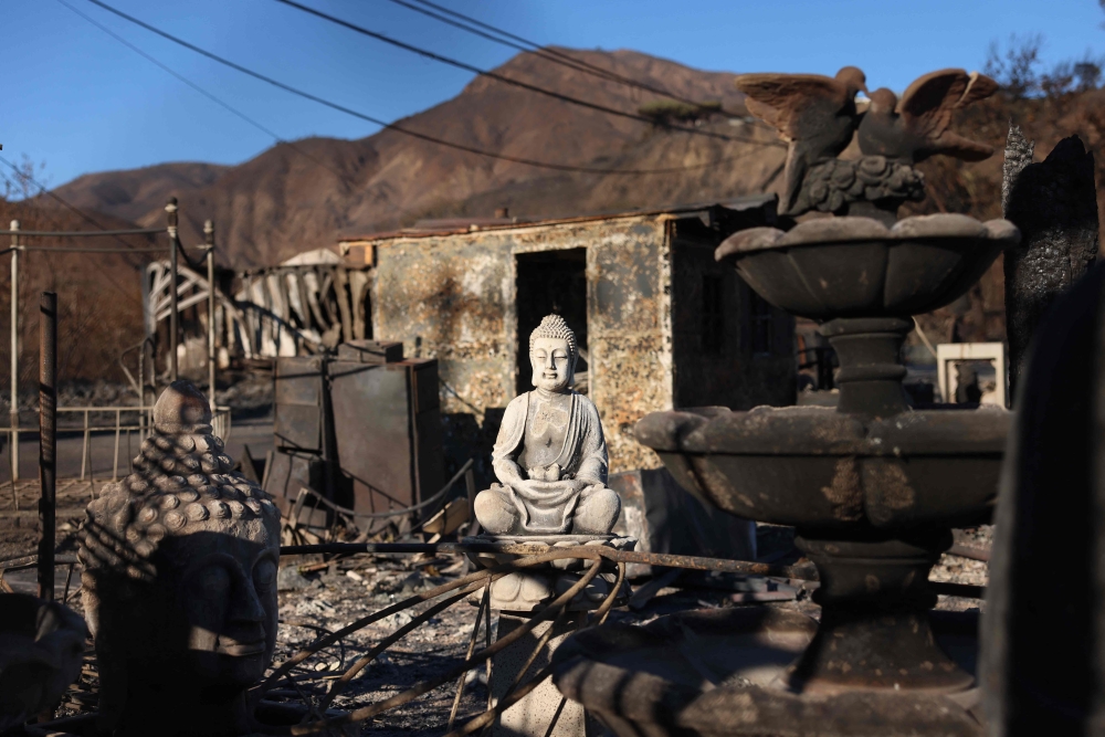 A Buddha statue sits in a burned lot as the Palisades Fire continues to grow. Police have warned against a looter disguised himself as a firefighter to raid a home around fire-wrecked Malibu.— AFP pic